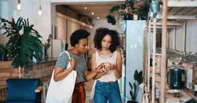 Image of consumers in a shop reviewing product packaging Image of consumers in a shop reviewing product packaging